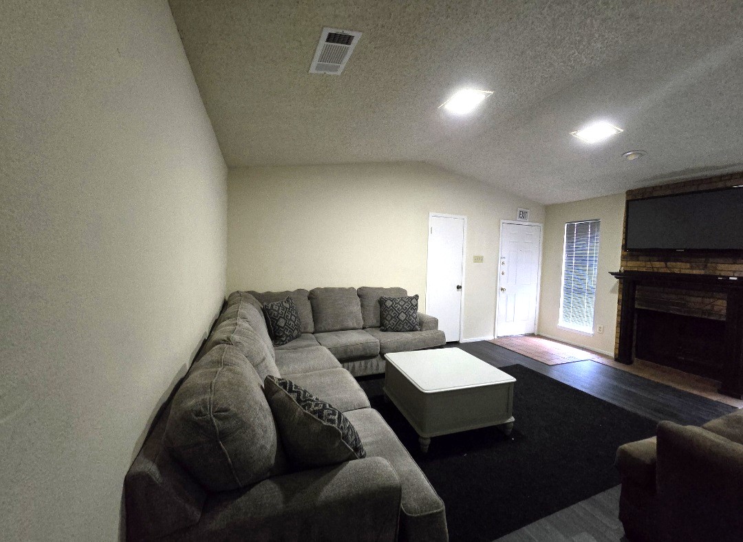 Shared living room at The Argo House with a sectional sofa, coffee table, and mounted TV.